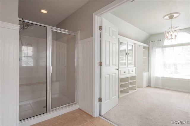 full bath with a shower stall, tile patterned flooring, and a chandelier