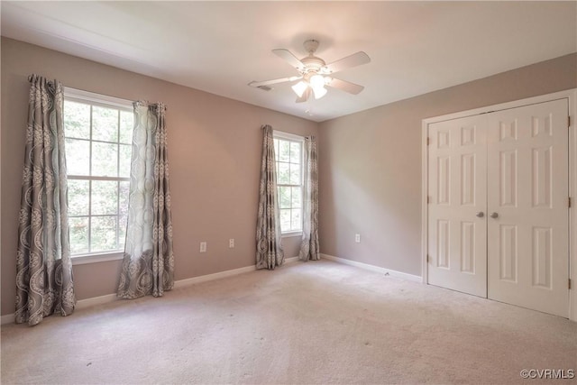 empty room featuring carpet flooring, baseboards, and a ceiling fan