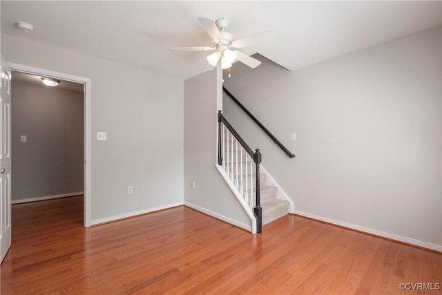 interior space featuring ceiling fan, baseboards, and wood finished floors