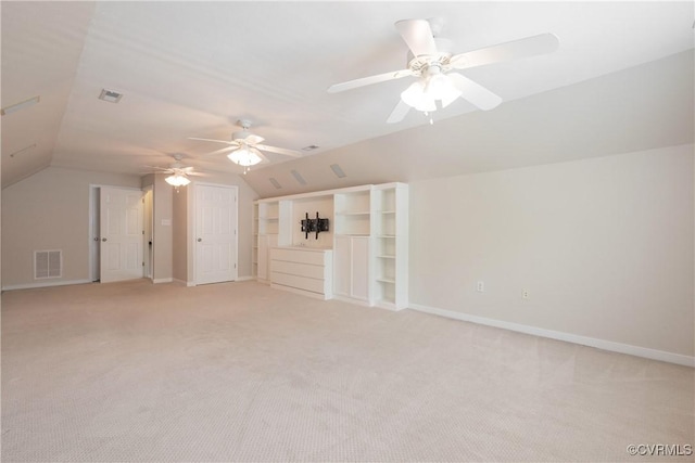 additional living space with lofted ceiling, ceiling fan, light carpet, and visible vents