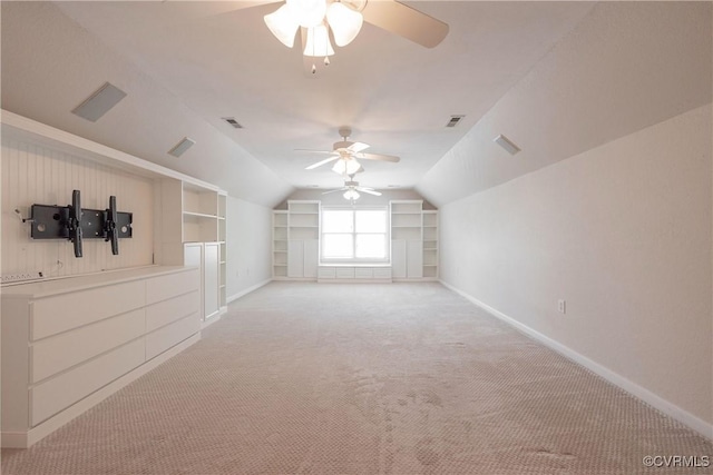 additional living space featuring a ceiling fan, light carpet, visible vents, baseboards, and vaulted ceiling