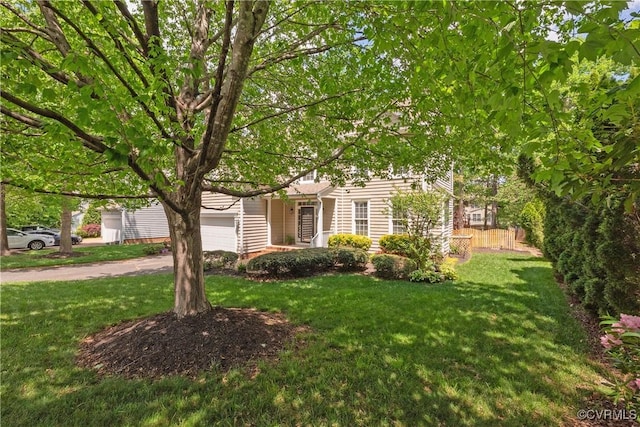 obstructed view of property featuring fence, a garage, and a front yard