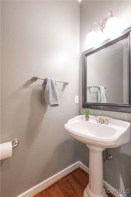 bathroom with wood finished floors and baseboards