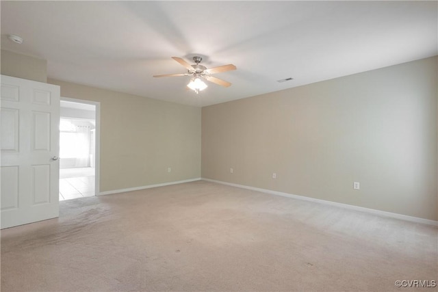 empty room featuring light carpet, baseboards, visible vents, and ceiling fan