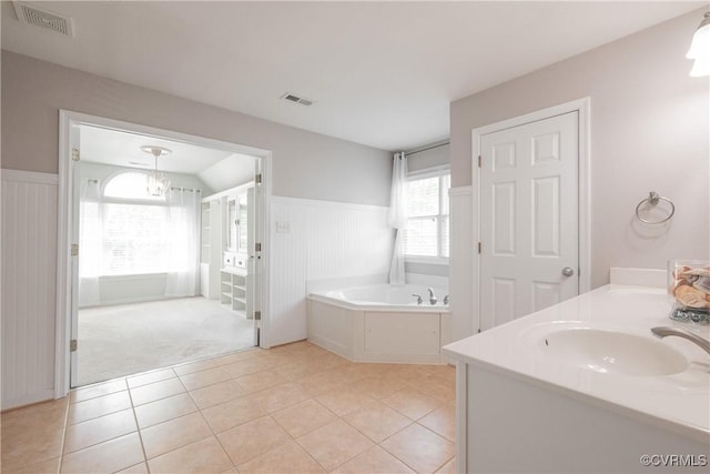 full bathroom featuring a sink, visible vents, tile patterned flooring, wainscoting, and a bath