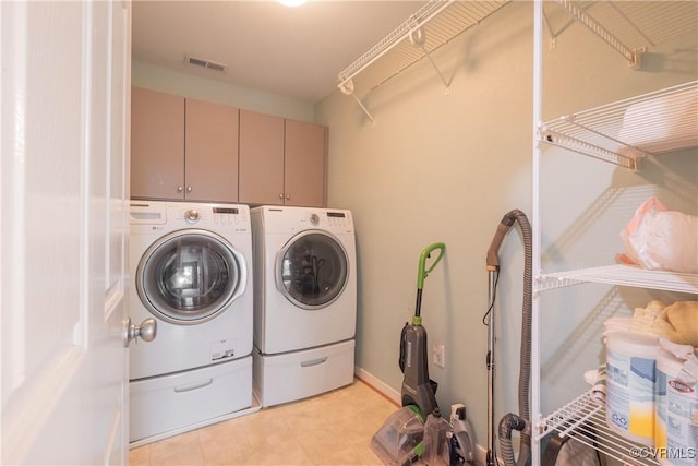 washroom featuring cabinet space, washing machine and clothes dryer, and visible vents