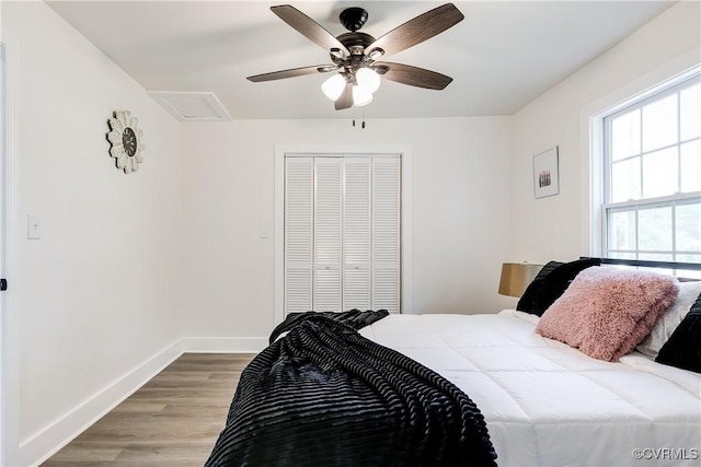 bedroom featuring baseboards, ceiling fan, a closet, and wood finished floors
