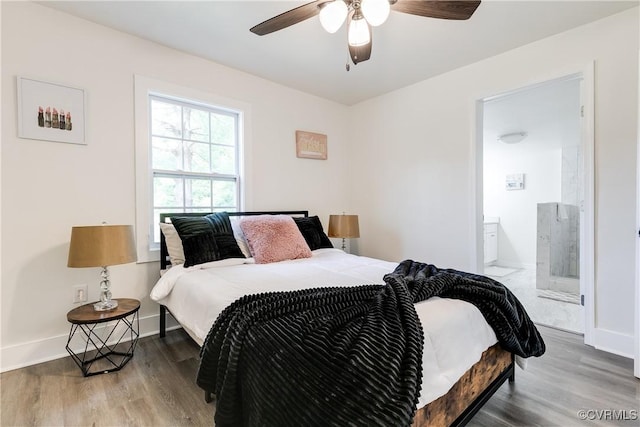 bedroom featuring baseboards, ceiling fan, wood finished floors, and ensuite bath