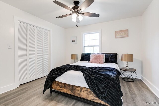 bedroom featuring a closet, baseboards, a ceiling fan, and light wood-type flooring