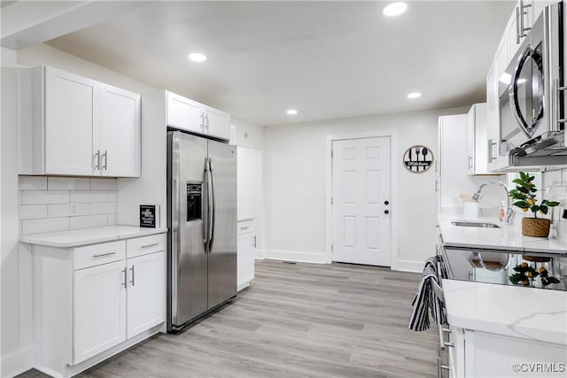 kitchen featuring a sink, appliances with stainless steel finishes, white cabinets, and recessed lighting