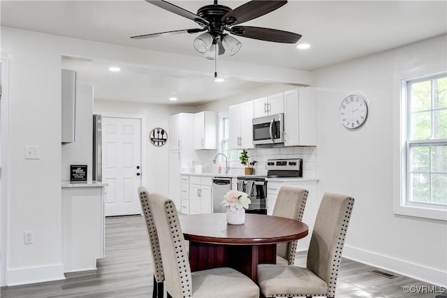 dining room featuring ceiling fan, light wood finished floors, recessed lighting, baseboards, and visible vents