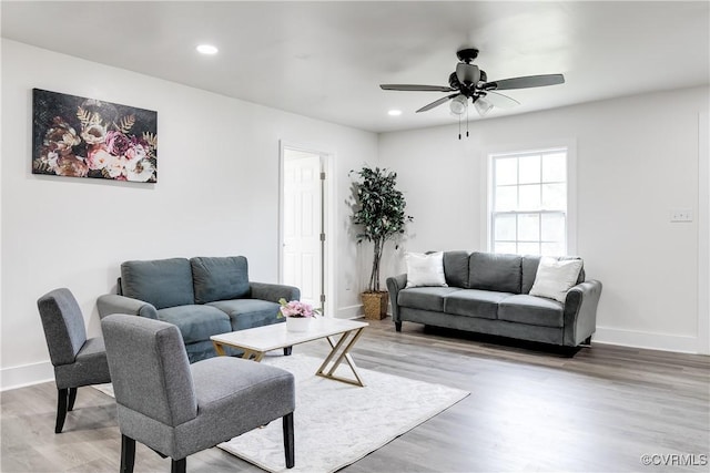 living area featuring baseboards, a ceiling fan, light wood finished floors, and recessed lighting