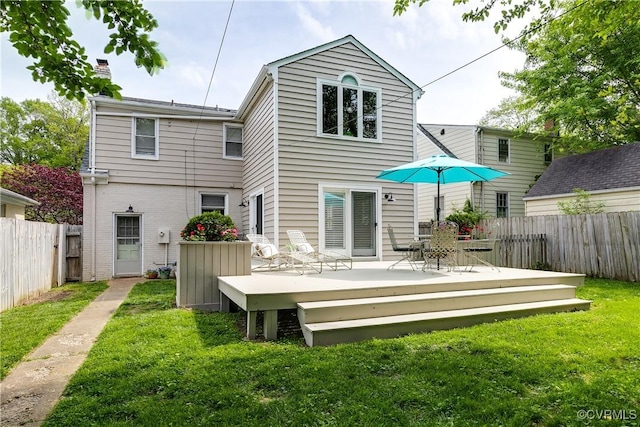 rear view of house with fence, a lawn, and a wooden deck