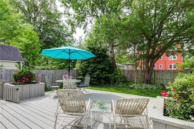 wooden deck featuring outdoor dining space and a fenced backyard