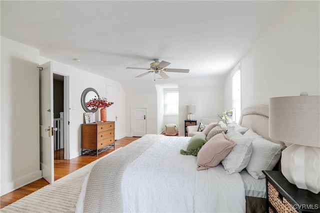 bedroom featuring baseboards, wood finished floors, and ceiling fan