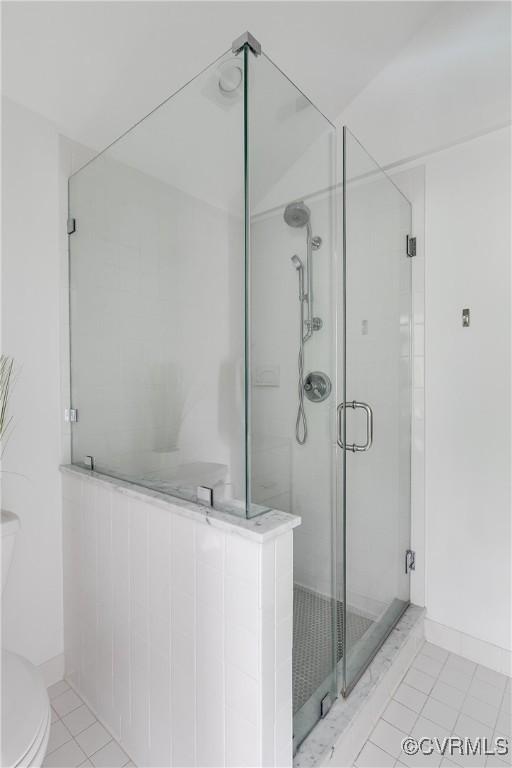 full bath with toilet and a shower stall