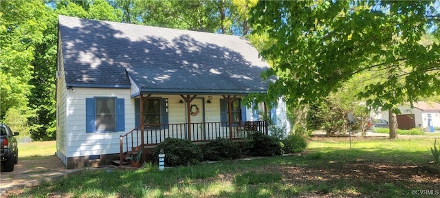 bungalow with a front yard, crawl space, covered porch, and roof with shingles