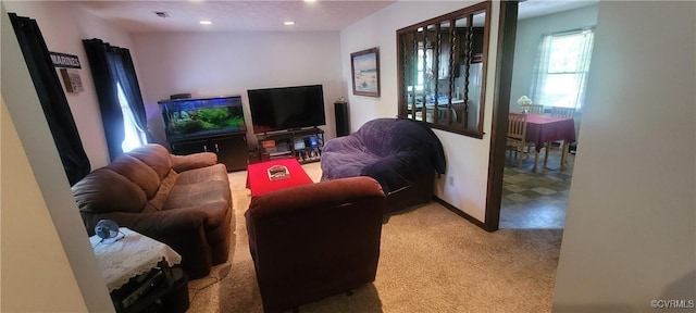 carpeted living area with visible vents and recessed lighting