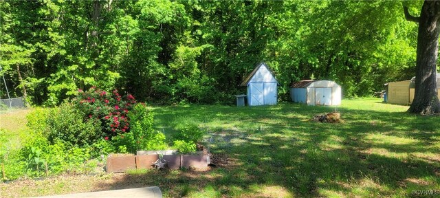 view of yard with fence, a storage unit, and an outdoor structure