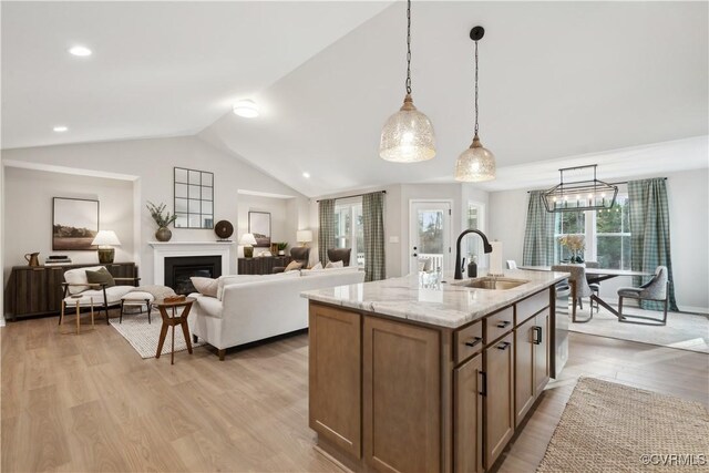 LOT12 Red Oak Cir Lot 12, Aylett, VA 23009 - kitchen with pendant lighting, light wood-style flooring, a sink, a glass covered fireplace, and light stone countertops