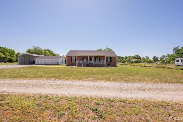 bungalow featuring a carport, dirt driveway, covered porch, fence, and a front lawn
