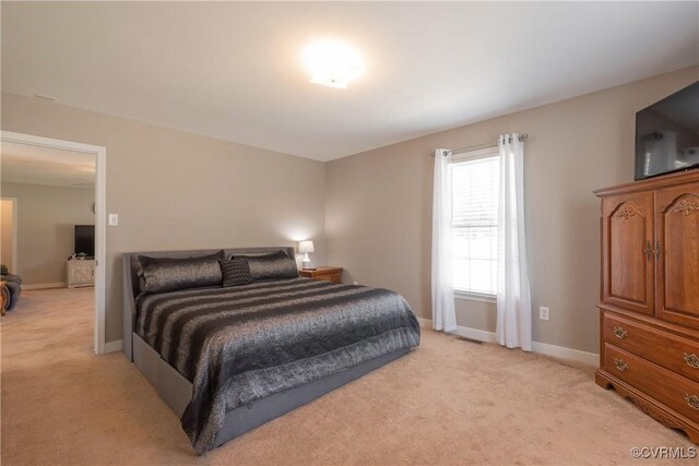 bedroom featuring light colored carpet and baseboards