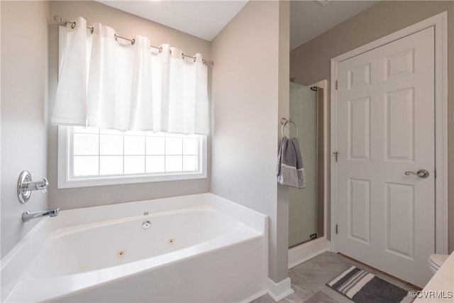 full bath featuring a tub with jets, a stall shower, marble finish floor, and baseboards