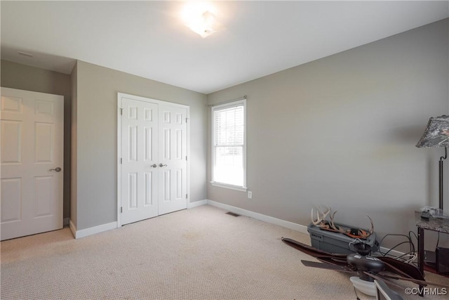 unfurnished bedroom with carpet, visible vents, a closet, and baseboards