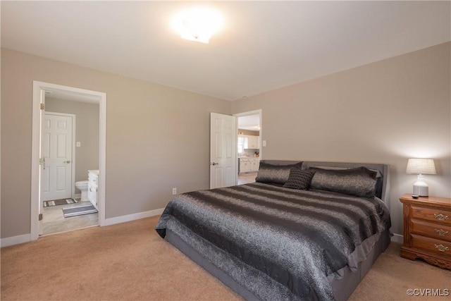 bedroom with light colored carpet, connected bathroom, and baseboards