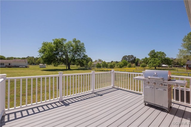 wooden deck featuring a yard and a grill