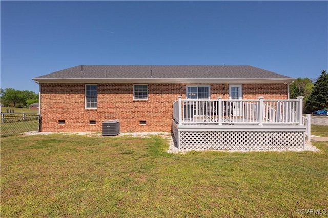 back of house with a yard, brick siding, fence, a wooden deck, and crawl space