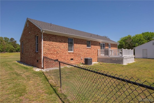 rear view of property featuring fence, a wooden deck, a yard, and central air condition unit