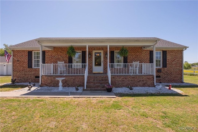 single story home featuring covered porch, a front yard, and brick siding