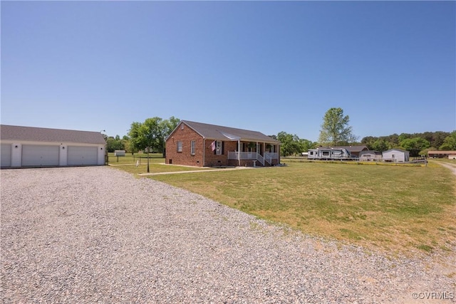 single story home featuring a front yard, a garage, covered porch, and brick siding
