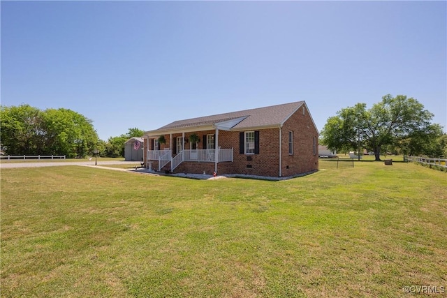 view of front of property featuring covered porch, crawl space, fence, brick siding, and a front lawn
