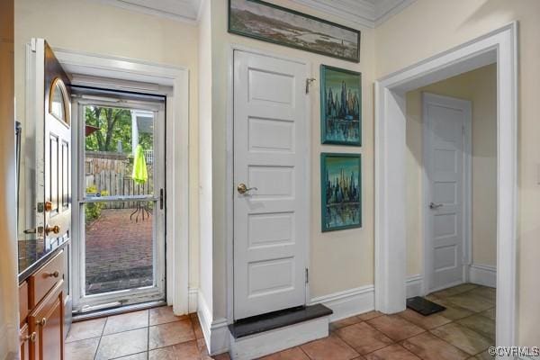 doorway featuring baseboards, ornamental molding, and light tile patterned floors
