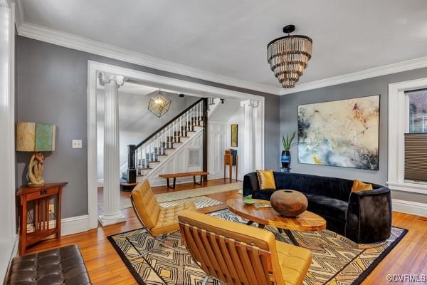 living room with crown molding, baseboards, and stairway