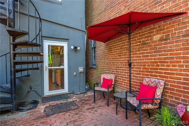 property entrance featuring brick siding and a patio area