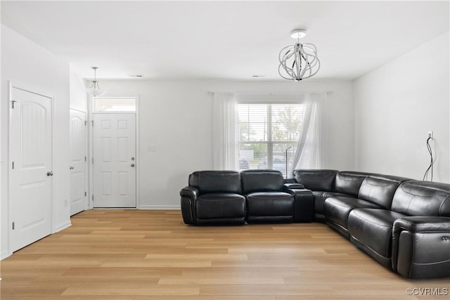 living area featuring an inviting chandelier, light wood finished floors, and a healthy amount of sunlight