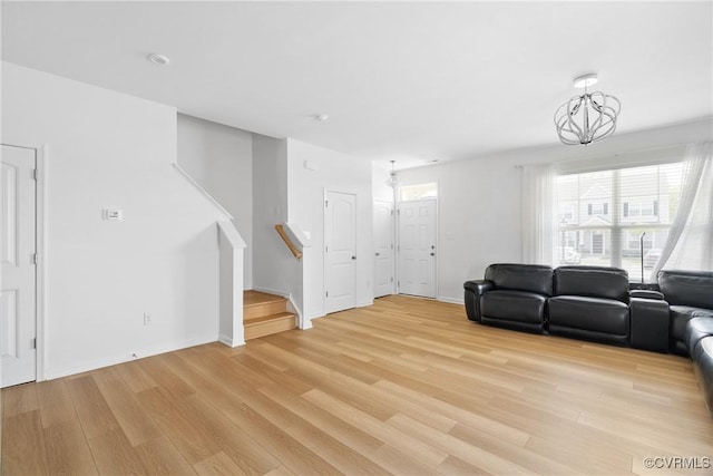 living room with stairs, baseboards, a healthy amount of sunlight, and light wood finished floors
