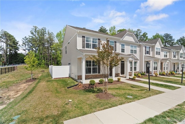 view of front of home featuring fence and a front lawn