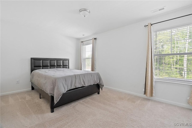 carpeted bedroom featuring visible vents and baseboards