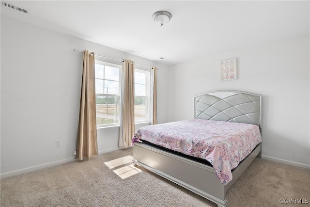 carpeted bedroom featuring visible vents and baseboards