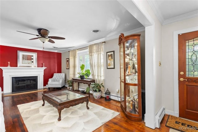 living room featuring a baseboard radiator, a healthy amount of sunlight, wood finished floors, and a ceiling fan