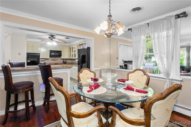 dining space with wood finished floors, a baseboard heating unit, ceiling fan with notable chandelier, visible vents, and crown molding