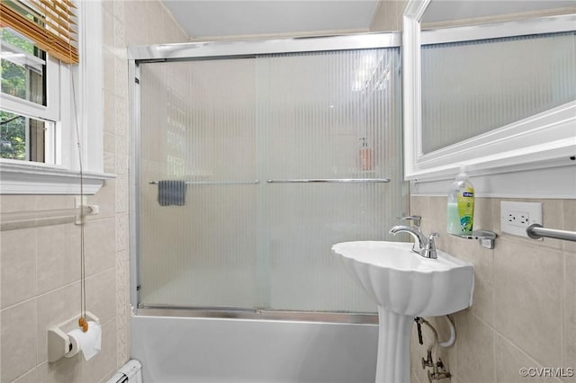 full bath with bath / shower combo with glass door and tile walls