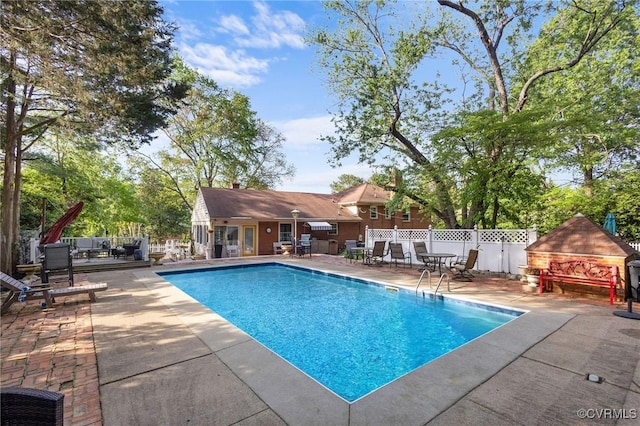 view of swimming pool with a patio, a fenced in pool, and fence