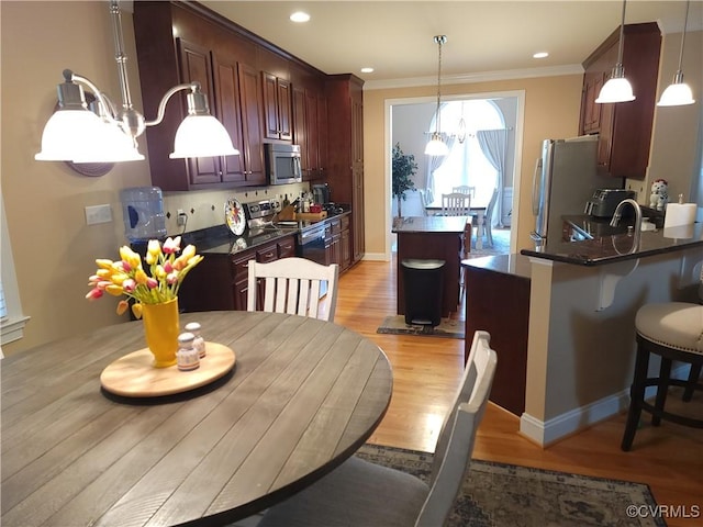 8313 Kalliope Ct, Chesterfield, VA 23838 - kitchen featuring stainless steel appliances, a chandelier, a center island, dark countertops, and ornamental molding