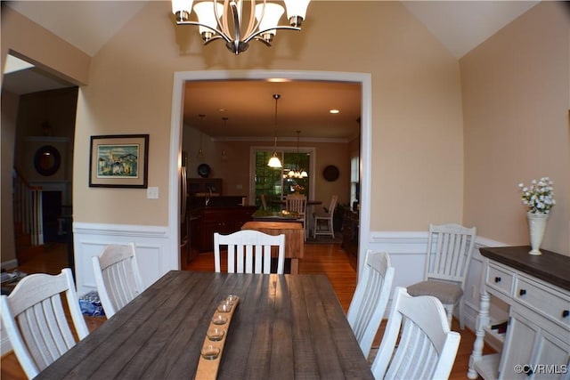8313 Kalliope Ct, Chesterfield, VA 23838 - dining area featuring a chandelier, lofted ceiling, wainscoting, a decorative wall, and wood finished floors