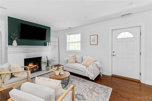 living area featuring visible vents, wood finished floors, a fireplace, baseboards, and recessed lighting